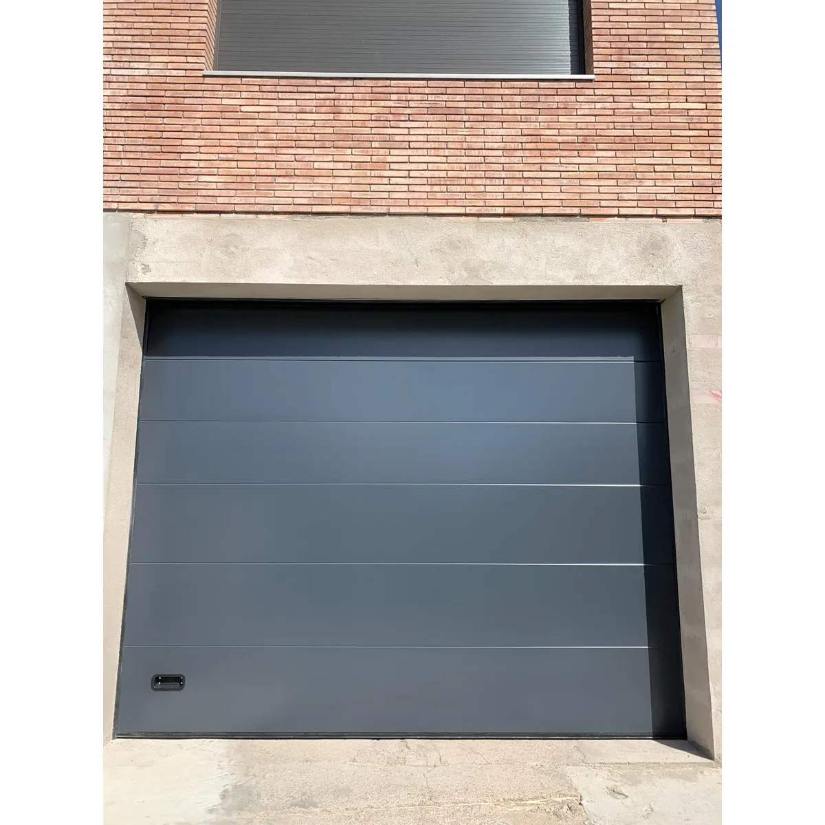 Puerta seccional instalada en un acceso de grandes dimensiones